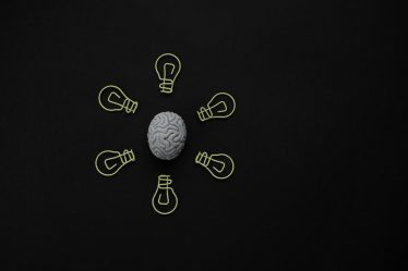 Ilustração de cérebro com lâmpadas em volta representando uma ideia