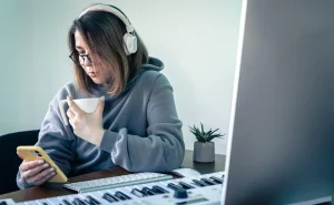 Mulher usando fones de ouvido enquanto escuta podcasts no celular enquanto toma um café. Ideal para quem busca melhorar a experiência com Daily Listen x Podcasts.